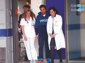 McLaren’s Fernando Alonso (centre) walks with medical staff as he leaves a hospital after suffering a concussion. (REUTERS)