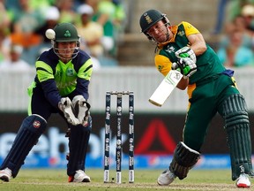 Ireland’s wicketkeeper Gary Wilson (left) can only watch as South Africa’s captain AB de Villiers smites a six during their Cricket World Cup match at Manuka Oval in Canberra. South Africa’s total of 411 runs was too much for Ireland to catch. (JASON REED/Reuters)