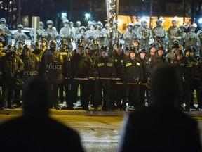 Protesters stare at a line of police officers and National Guard soldiers during a protest to demand justice for the killing of 18-year-old Michael Brown, outside the Ferguson Police Department in Ferguson, Missouri in this file photo taken November 28, 2014.   REUTERS/Lucas Jackson/Files