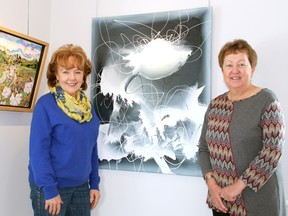 Clare Bloxam and Sheila Brown, exhibition planners at the Gallery in the Grove, showcase “July 9” by Lisa Finlayson, left, and “Grey Matter” by Kelly Gordon, two of the 62 pieces on display by 22 local art educators at the upcoming exhibit, Those Who Inspire: Art Teachers of Lambton County. The show opens on Sunday from 1-3 p.m. and runs until April 18. (TERRY BRIDGE/THE OBSERVER)