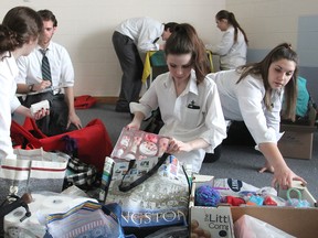 Students from Holy Cross Catholic Secondary School loads boxes and bags with personal hygiene items, sports equipment, first aid supplies and school supplies they will be taking with them on a humanitarian mission to Jamaica next week. (Michael Lea/The Whig-Standard)
