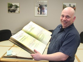 Bill Asselstine shows one of the old court ledgers kept by his grandfather, a justice of the peace, that he recently found in an old barn. (Michael Lea/The Whig-Standard)