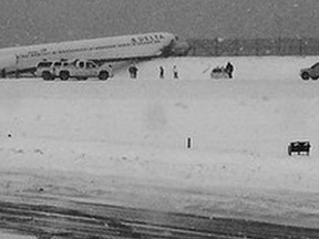 A Delta jet which skidded off the runway at Laguardia airport is attended by emergency personnel in New York City March 5, 2015. A Delta Air Lines plane slid off the runway at New York's LaGuardia Airport on Thursday during a snowstorm, NY 1 television and other media reported on Thursday.  REUTERS/Kristina Grossmann