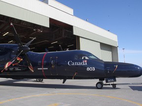 A Dash 8 aircraft is towed out of Hangar 16 at 17 Wing after Associate Minister of National Defence Julian Fantino announced $13 million in funding for hanger door upgrades and infrastructure for 17 Wing at a press conference in Winnipeg, Man. Thursday, March 5, 2015.