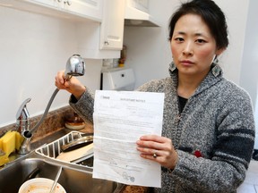Subin Yoo on Thursday, March 5, 2015 holds a notice she received from the city Feb. 26 stating she would have running water within 48-72 hours. Crews finally arrived March 5. (Veronica Henri/Toronto Sun)