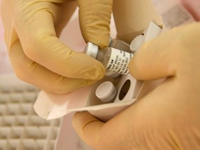 Scientists at the National Microbiology Lab in Winnipeg, Manitoba, prepare an experimental Ebola vaccine for shipment to the World Health Organization (WHO) in Geneva in this undated handout picture released October 18, 2014. (REUTERS/Public Health Agency of Canada/Handout)