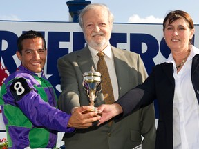 Trainer Josie Carroll (right) hold the trophy with jockey Luis Contreras (left) and owner Ivan Dalos after Ami's Holiday won the Breeders' Stakes at Woodbine Racetrack on Aug. 17, 2014. (MICHAEL BURNS files)