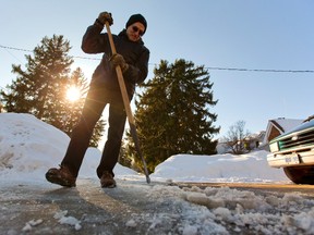 Jim Allen of Old South chops away at ice. (MIKE HENSEN, The London Free Press)