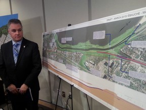 Ottawa Coun. Mark Taylor stands beside a map of the new proposed route for Ottawa's western LRT expansion. (JON WILLING Ottawa Sun)