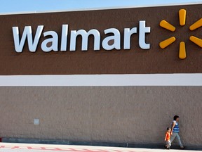 People walk past a Walmart sign in this June 4, 2009 file photo. (REUTERS/Jessica Rinaldi/Files)