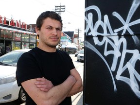Luis Vega, owner of El Arepazo on Augusta Ave., stands next to a graffiti tag on March 6, 2015. (Veronica Henri/Toronto Sun)