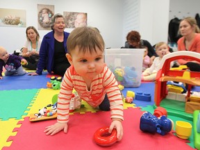 A child plays as MP Joyce Bateman meets with mothers and their children at the Nest Family Centre on Stafford Street to spread the word on family tax cuts the federal government introduced on Fri., March 6, 2015. (Kevin King/Winnipeg Sun file)