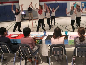 Sitting at a banquet table where all the placemats were dedicated to people who promoted social justice and equality, students at Lancaster Drive Public School watch dancers who were part of a multi-media performance that illustrated the negative effects of stereotyping and bullying. (Michael Lea/The Whig-Standard)