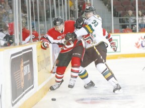 67?s forward Dante Salituro battles against the boards with Knights defenceman Julius Bergman during their OHL game Friday night at TD Place in Ottawa. The Knights tied the game in the final minute, then Bergman scored for a 6-5 overtime victory. (CHRIS HOFLEY, QMI Agency)