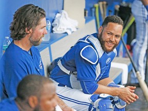 R.A. Dickey (left) and Russell Martin talk things over in the Blue Jays dugout during their game Friday against the O’s. (STAN BEHAL, Toronto Sun)