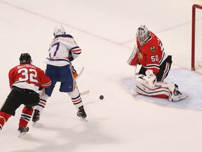Mar 6, 2015; Chicago, IL, USA; Edmonton Oilers left wing Benoit Pouliot (67) shoots the puck as Chicago Blackhawks goalie Corey Crawford (50) defends during the first period of an NHL game at United Center. Mandatory Credit: Kamil Krzaczynski-USA TODAY Sports