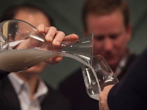 Sommeliers Larry Stone and Paul Roberts, both of Napa, California, pour wine recovered from a shipwreck at the Wine + Food Festival in Charleston, South Carolina, March 6, 2015. (REUTERS/Randall Hill)