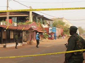 A soldier stands outside La Terrasse restaurant (top C) where militants killed five people, including a French citizen and a Belgian citizen, in a gun attack in Bamako March 7, 2015. One of the five people killed was a Belgian security officer with the European Union delegation in Mali, EU foreign policy chief Federica Mogherini said on Saturday. REUTERS/Adama Diarra