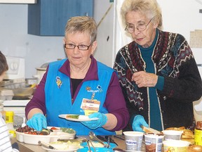 Wal-Mart's Linda Brown, left, and longtime volunteer Cathy Tiffin serve breakfast at A.A. Wright on Feb. 25. The local Wal-Mart and Breakfast Clubs of Canada is raising $4,000 for local breakfast programs. Wal-Mart employees also volunteer at local schools.