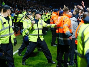 Police clash with fans who ran onto on the field after Aston Villa beat West Bromwich Albion in FA Cup quarterfinal play Saturday. (REUTERS)