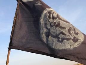 A Boko Haram flag flutters from an abandoned command post in Gamboru deserted after Chadian troops chased them from the border town on February 4, 2015. Nigerian Boko Haram fighters went on the rampage in the Cameroonian border town of Fotokol, massacring dozens of civilians and torching a mosque before being repelled by regional forces. AFP PHOTO/STEPHANE YAS