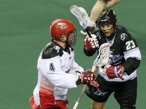Calgary Roughnecks Geoff Snider is harassed by  Edmonton Rush Jarrett Davis in NLL lacrosse action at the Scotiabank Saddledome in Calgary, Alta. on Saturday December 20, 2014. Mike Drew/Calgary Sun
