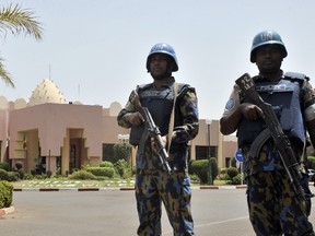UN peacekeeper police officers stand guard at entrance of Hotel Salem in Bamako on March 8, 2015. Two civilians and a UN peacekeeper were killed as militants attacked a barracks used by the United Nations' MINUSMA force in northern Mali.  A MINUSMA source told AFP the civilian victims were members of the nomadic Arab Kunta tribe, which is spread across the Saharan regions of Mali, Algeria, Mauritania and Niger.  AFP PHOTO / HABIBOU KOUYATE