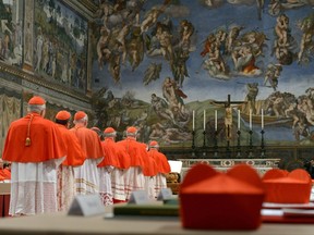 Cardinals enter the Sistine Chapel to begin the conclave in order to elect a successor to Pope Benedict March 12, 2013. Shut off from the outside world, the 115 cardinals will cast their ballots in a chapel which has Michelangelo's soaring Last Judgment on one wall, and his depiction of the hand of God giving life to Adam above them.      REUTERS/Osservatore Romano