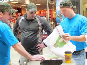 CANstruction builders from SNC-LAVALIN, Mike McLean, left, Ryan Henry, centre, and Dave Beaudoin, right, review plans for a sculpture of donated food.
NEIL BOWEN/ SARNIA OBSERVER/ QMI AGENCY