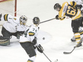 Frontenacs forward Lawson Crouse takes a swipe at a rolling loose puck in front of London Knights goalie Tyler Parsons during the second period of their OHL game at the Rogers K-Rock Centre in Kingston on Sunday. The Fronts won 4-3.  (JULIA MCKAY, QMI Agency)