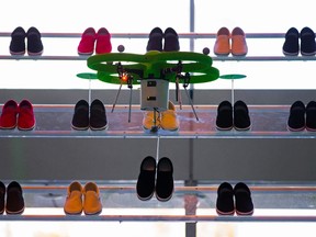 A drone picks up a pair of shoes during a presentation by the Crocs footwear company in Tokyo, in this March 5, 2015 file picture. REUTERS/Thomas Peter/Files
