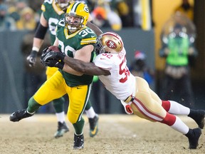 Green Bay Packers fullback John Kuhn (30) runs with the ball as San Francisco 49ers linebacker Patrick Willis (52) tackles during the second quarter of the 2013 NFC wild card playoff football game at Lambeau Field. (Jeff Hanisch-USA TODAY Sports)