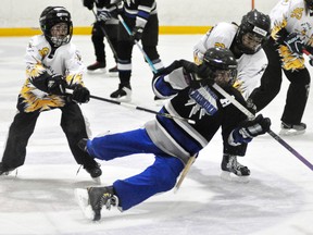 Ashtyn Wedow (left) and Jenna Deck combine to take down this St. Thomas player during U12 ringette action last Saturday in Mitchell. The battle for first place saw the visitors rally from a 2-1 deficit and defeat the Stingers 6-3. ANDY BADER/MITCHELL ADVOCATE