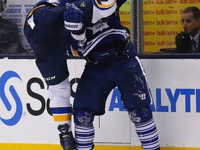 Roman Polak of Toronto gets tied up with Ryan Reaves of St. Louis. The Toronto Maple Leafs lost 6-1 to the St. Louis Blues in Toronto on March 7, 2015. (MICHAEL PEAKE/Toronto Sun)