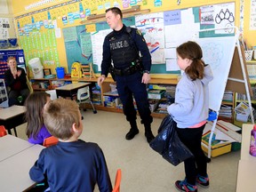 Emily Mountney-Lessard/The Intelligencer 
OPP Emergency Response Team member Cst. Matt Raycroft, with Quinte West OPP Cst. Maggie McCaughen (back left) teach the Hug-A-Tree survival program to Grade 2 students at Bayside Public School, Monday, March 9, 2015, in Bayside.