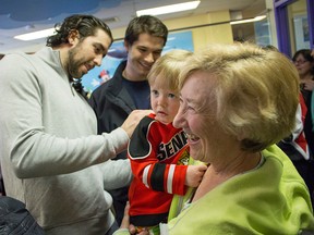 Jared Cowen and Matt Puempel signing Evelyn's hockey jersey at the unveiling of the new Smilezone at the Ottawa Children's Treatment Centre Monday. (DANI-ELLE/OTTAWA SUN)