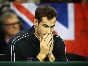 Britain's Andy Murray reacts as his teammates Britain's Dominic Inglot and Jamie Murray compete against Mike Bryan and Bob Bryan of U.S. during the Davis Cup third round doubles tennis match at the Emirates Arena in Glasgow, Scotland on March 7, 2015. (AFP PHOTO/IAN MACNICOL)