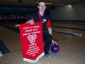 Ryan Locker of Aylmer kneels with his provincial championship banner at Heritage Lanes in St. Thomas. (Ben Forrest, Times-Journal)