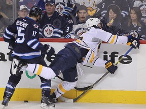 Winnipeg Jets right winger Matt Halischuk checks Buffalo Sabres centre Mikhail Grigorenko during NHL hockey at the MTS Centre on December 16, 2014. (Brian Donogh/Winnipeg Sun/QMI Agency)