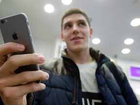 A customer holds the newly released iPhone 6 at a mobile phone shop in Moscow, Sept. 26, 2014. REUTERS/Maxim Shemetov