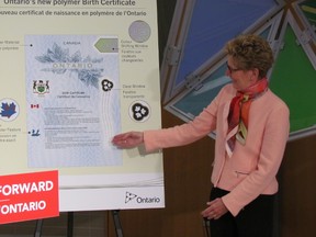 Ontario Premier Kathleen Wynne unveils new polymer birth certificate on Tuesday, March 10, 2015 to help reduce fraud. (Toronto Sun/Antonella Artuso)