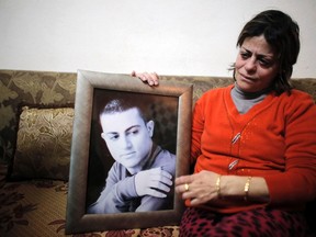 The mother of Muhammad Musallam, an Israeli Arab held by Islamic State in Syria as an alleged spy, weeps as she holds his photograph in her East Jerusalem home February 12, 2015. (REUTERS/Ammar Awad)
