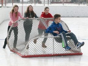 Aeden Loschiavo is pushed on a hockey net by friends (l-r) M Stangl, Victoria Romero and Bridget Smith at the River Heights Community Club as temperatures hit 4C in Winnipeg, Man. Monday March 9, 2015.