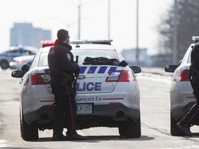 Two Ottawa Police Officer's patrol Carling Avenue armed with high powered rifles during a standoff with a man who barricaded himself in his apartment. March 10, 2015. Errol McGihon/Ottawa Sun/QMI Agency