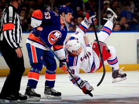 Jesper Fast #19 of the New York Rangers is tripped by Casey Cizikas #53 of the New York Islanders prior to a faceoff during a game at the Nassau Veterans Memorial Coliseum on March 10, 2015 in Uniondale, New York. (Alex Trautwig/Getty Images/AFP)
