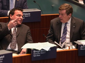 Councillor Giorgio Mammoliti waves his middle finger around Mayor John Tory on March 11, 2015. Mammoliti said the middle finger was a message from his residents on garbage bin fee hikes. (Craig Robertson/Toronto Sun)