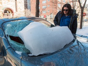 Jonathan Reeves surveys the damage to his car, which was crushed by a massive piece of ice that slid off the building where he lives on Cooper St. in downtown Ottawa on March 11, 2015. Errol McGihon/Ottawa Sun/QMI Agency