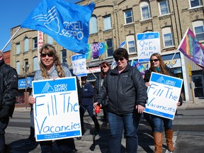 Unionized employees of Community Living Elgin march across Talbot St. on Wednesday as part of an information picket. They were protesting what they say are planned layoffs and other unfair workplace practices. (Ben Forrest/Times-Journal)