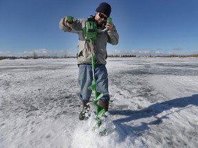 Ian Carter drills holes through ice at FortWhyte Alive March 10, 2015.