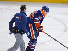 Edmonton defenceman Nikita Nikitin (86) skates off the ice with a team medical staffer trailing after a hit in a game against Buffalo0 in January. (Ian Kucerak, Edmonton Sun)